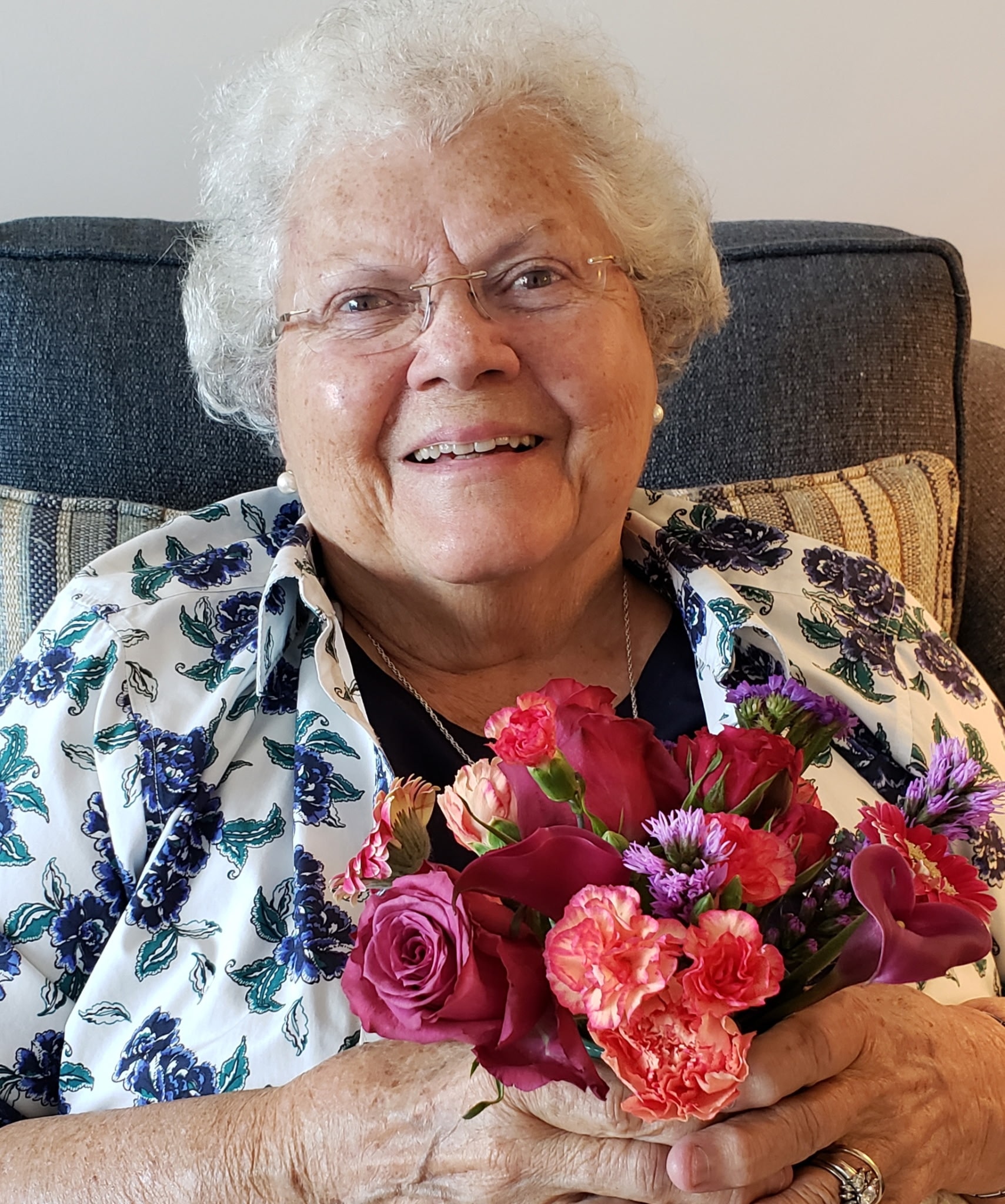 Senior woman holding a colorful flower bouquet, full of joy — Peaceful Place Home Care, Matthews NC